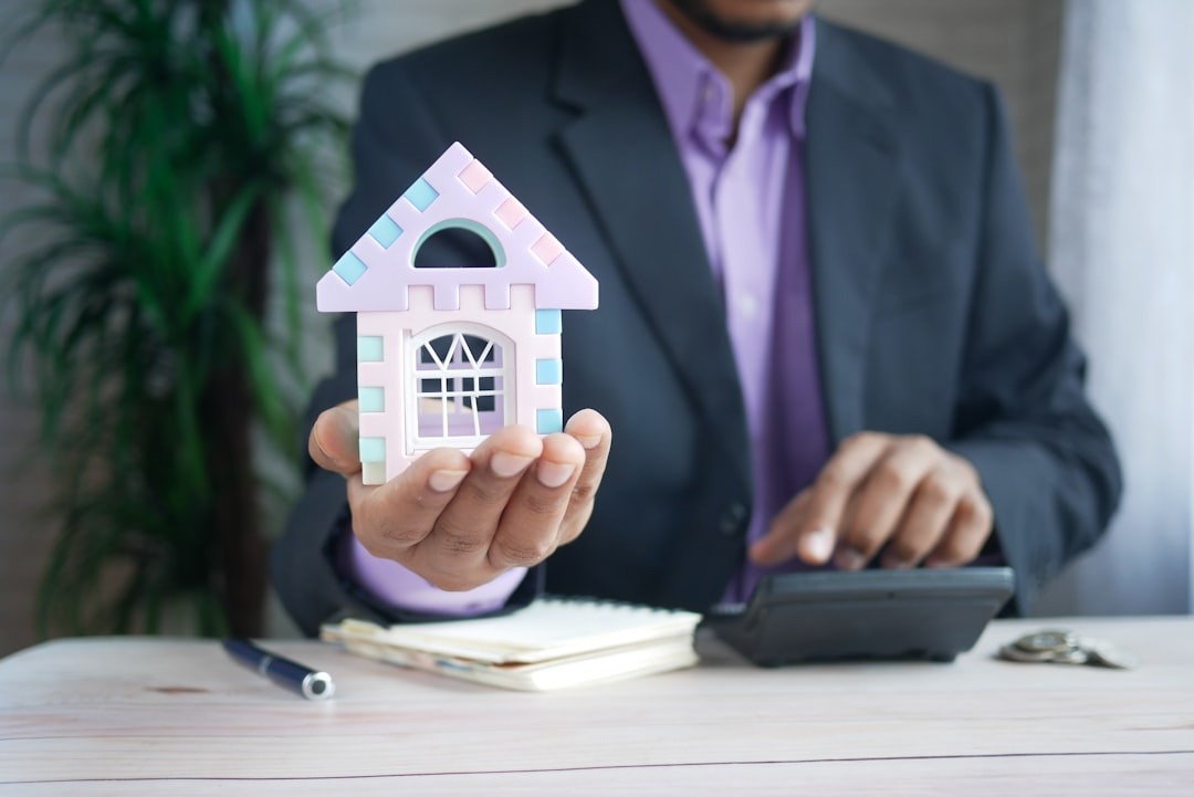 A small house in hand of man with full dress coat in table